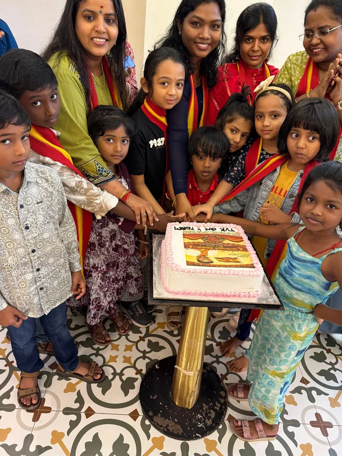குழந்தைகளும் மகளிரும் இணைந்து கேக் வெட்டும் காட்சி.